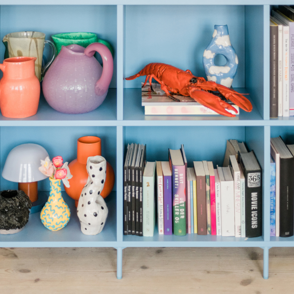 The open sections of a Sky Blue Type02 Sideboard are shown filled with books, colourful objects and decor.