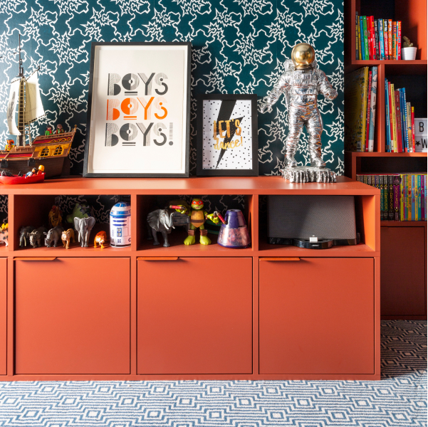 A stylish kids' room with bright wallpaper is furnished with a Terracotta Type02 with a row of closed door storage topped with open sections filled with toys, figurines and children's treasures.
