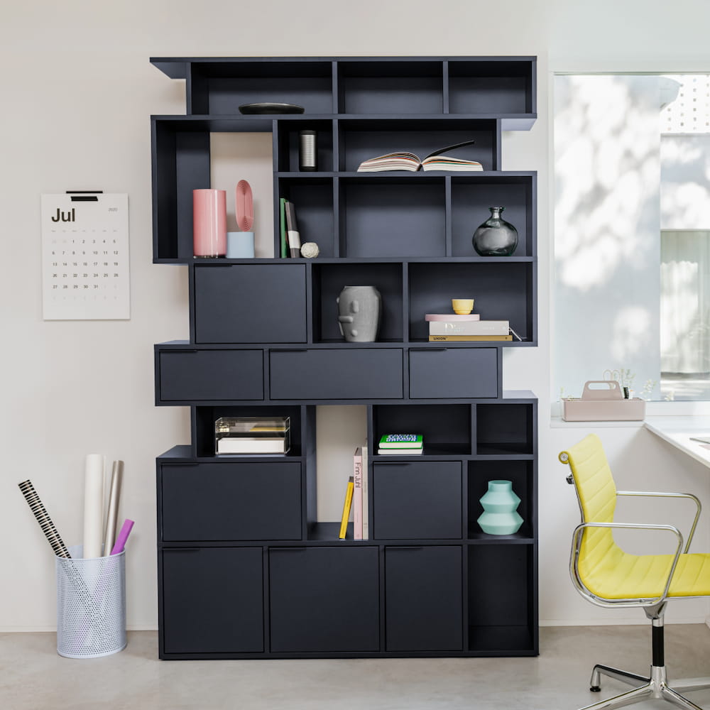 A tall, sleek Type02 Wall Storage in Midnight Blue stands in a trendy office with eight rows of mixed style storage arranged in a Pattern layout.