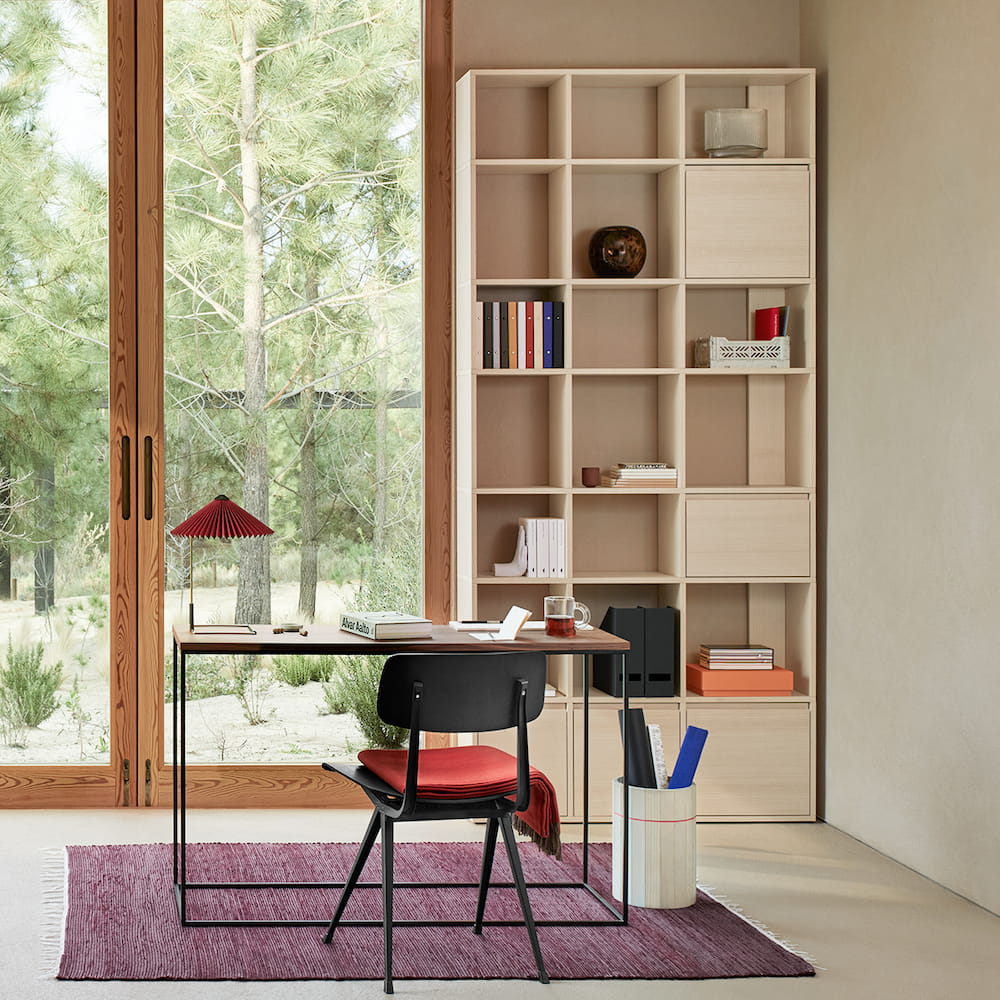 A slim white Type01 Veneer Sideboard in Ash stands snugly in an office corner with seven rows of storage, the bottom of which is closed door compartments.
