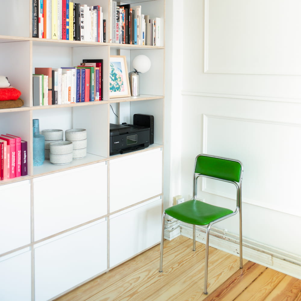 A bright white Type01 Wall Storage holds office supplies, books and more on in four open rows of deep compartments and two rows of deep drawers.