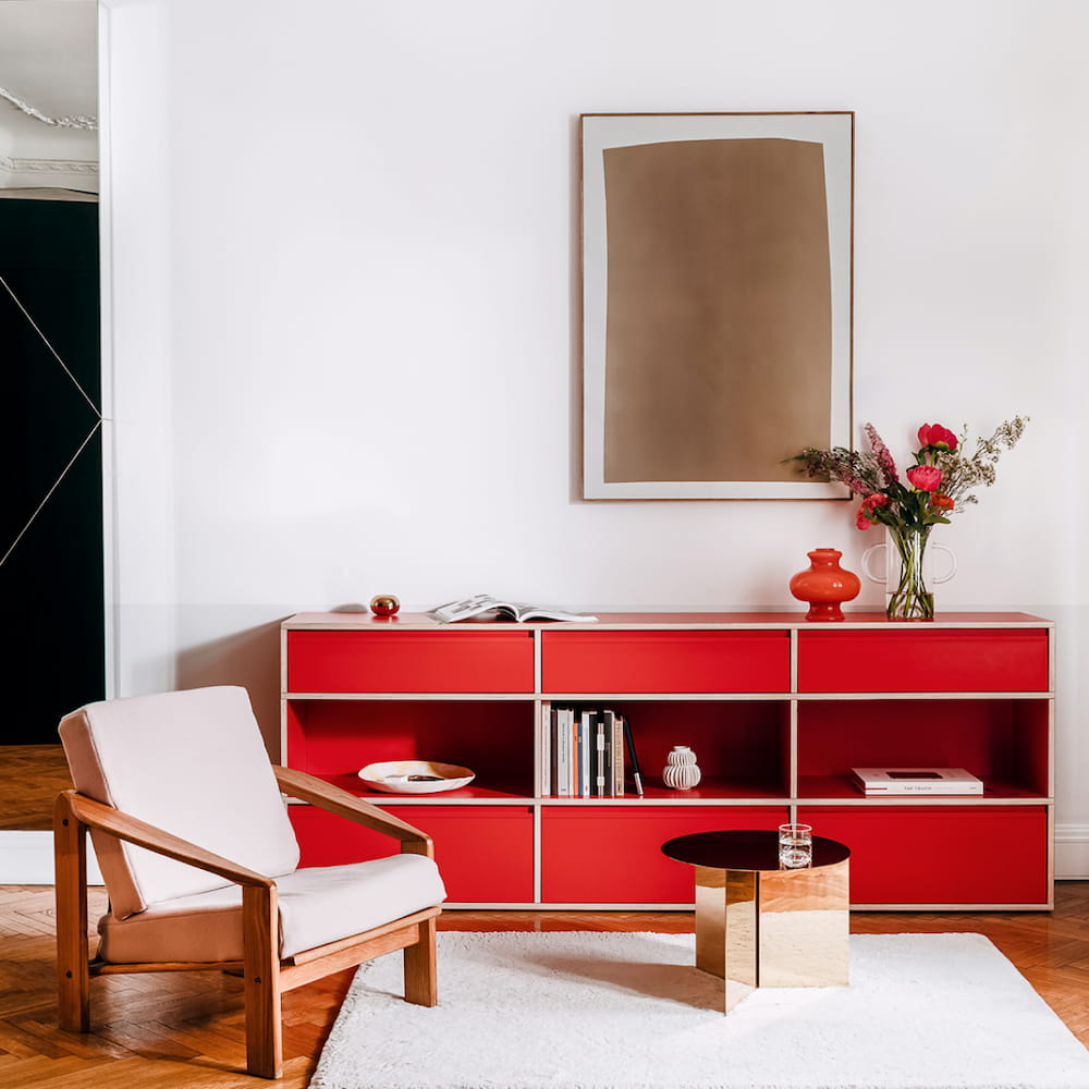 A three-section, three-row Type01 Sideboard in classic red sets off a white living room with its two rows of drawers separated by an open row displaying books and objects.
