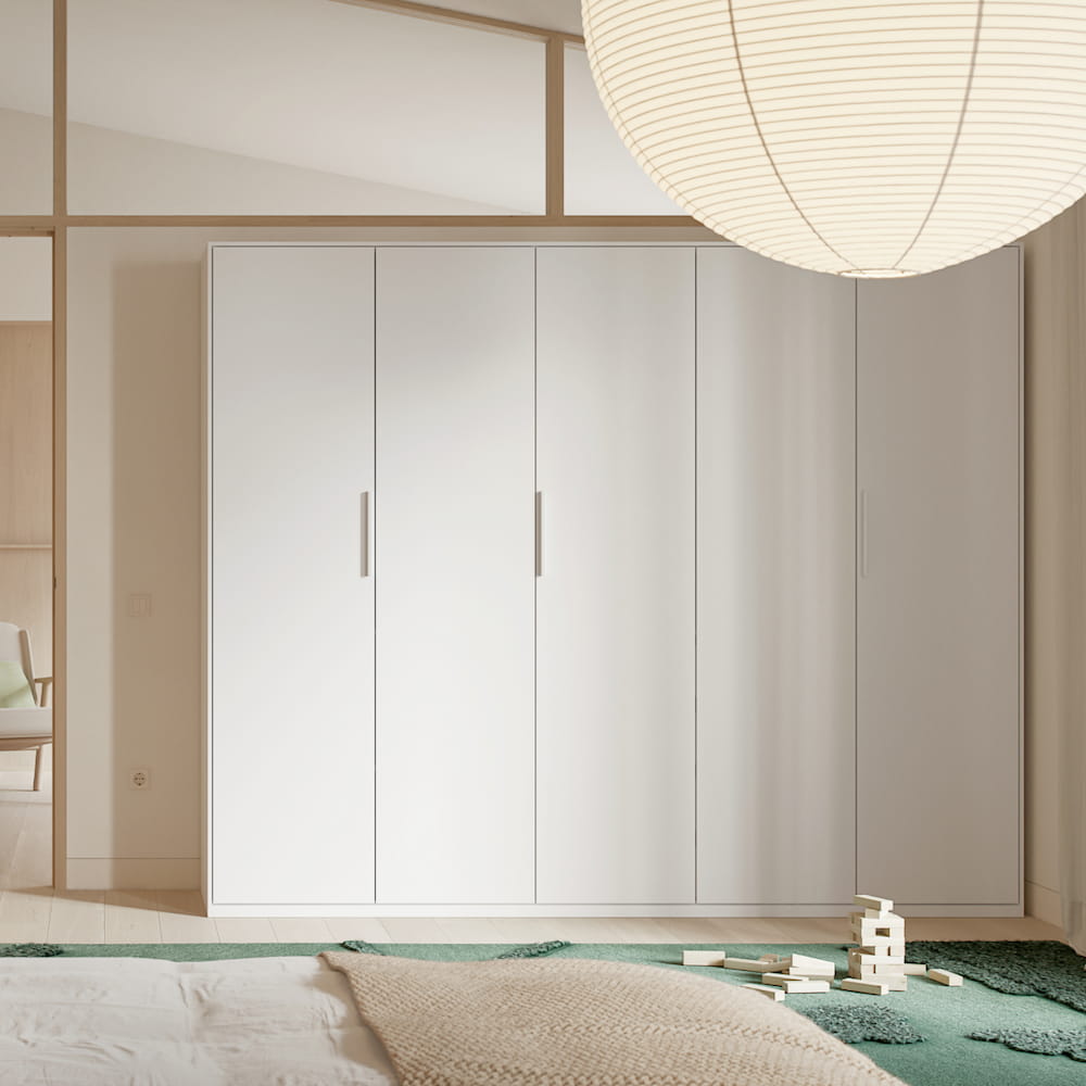 A high, wide Tone Wardrobe in white with 5 slim doors stands in a neutral-toned bedroom.